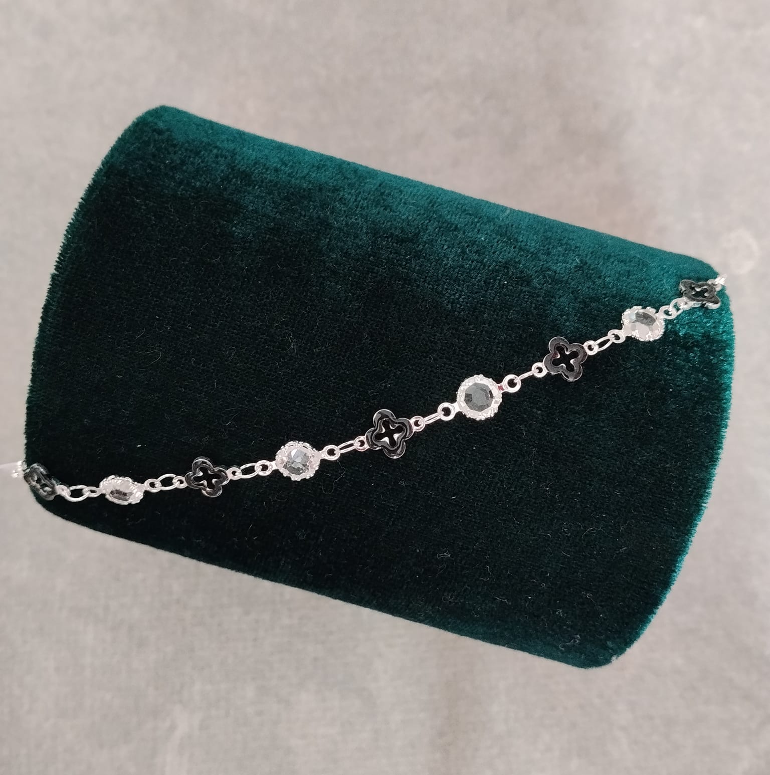Foto de Pulseira prateada com mini trevo preto e pedras transparentes