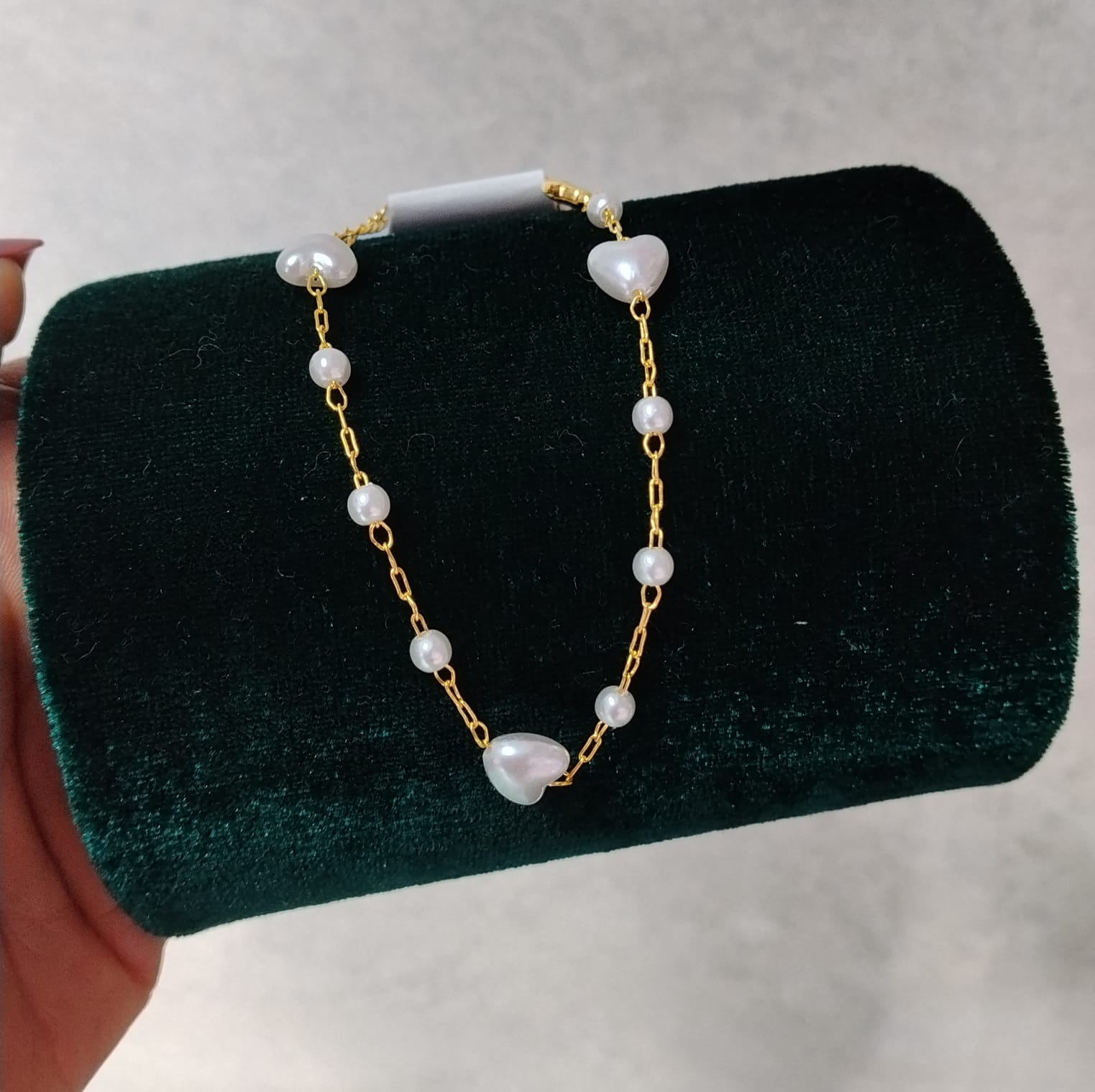 Foto de Pulseira dourada de bolinha e coração branco
